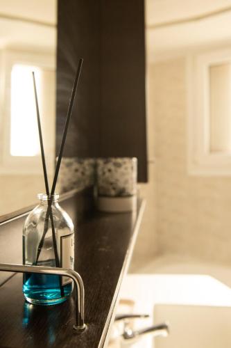 a vase with two sticks in it on a bathroom counter at Konstan'shouse in Mytilene