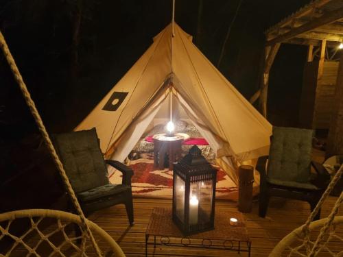 a tent with two chairs and a table and a lamp at Petit coin de Paradis in Saint-Michel-de-Lanès