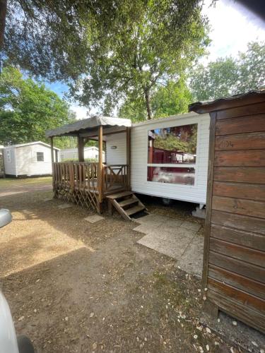 a small white trailer with a gazebo at Camping 4 Étoiles Mobilhome Chez Jéjé et Fredo in Saint-Jean-de-Monts