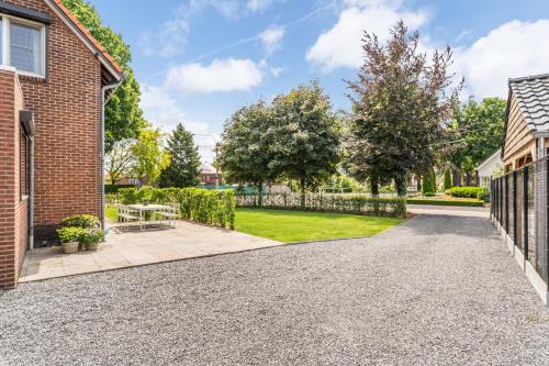 a driveway of a home with a fence at Vakantiewoning 't Hovenshuis in Kinrooi