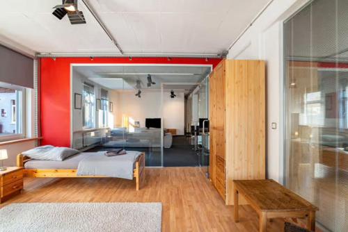 a bedroom with a bed and a red wall at 140 qm großes Loft mit 2 eigenen Schlafzimmern im Fabrikstil - direkt in Groß-Umstadt - 300 m bis zum Marktplatz in Groß-Umstadt