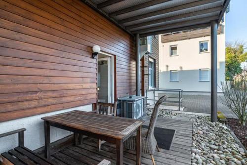a wooden deck with a table and chairs on a house at 140 qm großes Loft mit 2 eigenen Schlafzimmern im Fabrikstil - direkt in Groß-Umstadt - 300 m bis zum Marktplatz in Groß-Umstadt