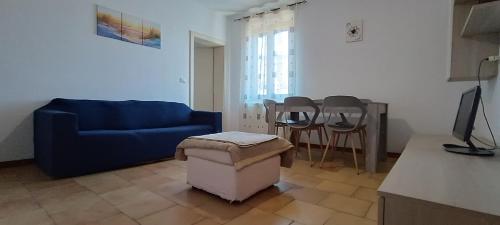 Una sala de estar con un sofá azul y una mesa. en Casa Navacchio, en Navacchio