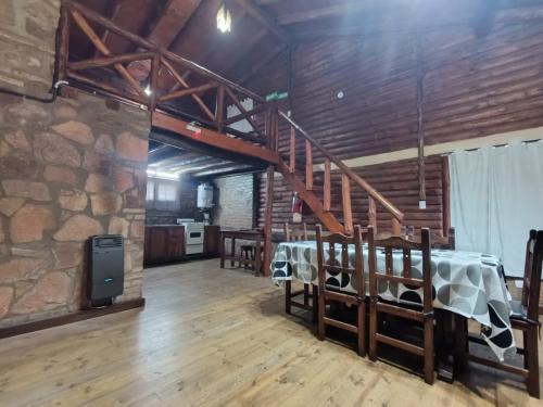 una camera con tavolo e parete in pietra di Cabañas Postal de la Villa a Villa Carlos Paz