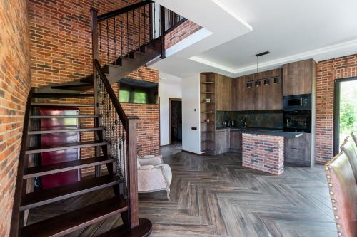 a living room with a staircase and a brick wall at Galuonų vilos in Inturkė