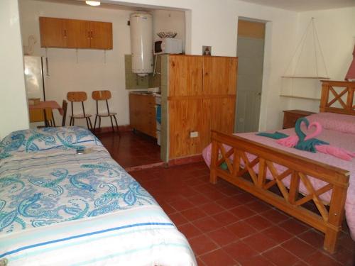 una camera con letto e una cucina con sedie di Alquimia a Capilla del Monte