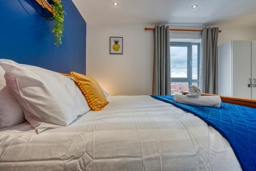 una camera da letto con un letto grande con una parete blu di The Contractor City Spot with Parking a Derby