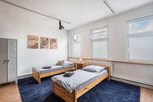 a bedroom with two beds and two windows at 40 qm große Studiowohnung zentral gelegen - direkt in Groß-Umstadt - 300 m bis zum Marktplatz in Groß-Umstadt