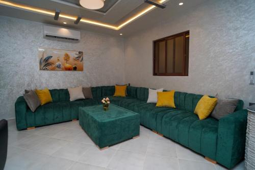 a living room with a green couch and yellow pillows at Luxury apartment in Tangier 3 in Tangier