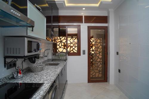 a kitchen with granite counter tops and a door at Luxury apartment in Tangier 3 in Tangier