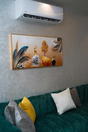 a green couch in a living room with a picture on the wall at Luxury apartment in Tangier 3 in Tangier