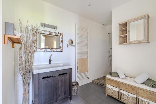 un bagno con lavandino e specchio di Maison Les Marronniers a Montagne