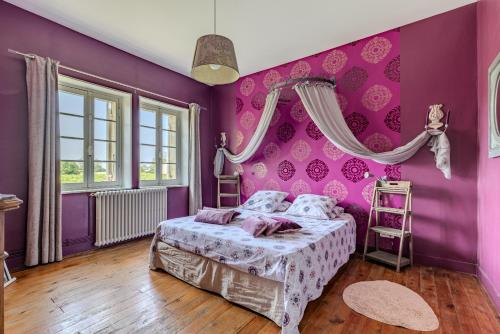 una camera con pareti viola e un letto di Maison Les Marronniers a Montagne