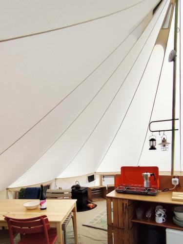 a sail of a boat with a table and chairs at Voedselbos Camping Koperwiek in Hazerswoude-Dorp