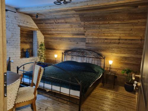 a bedroom with a wooden wall with a bed in it at Pokoje Dla Rodzin z Dziećmi in Sierpnica