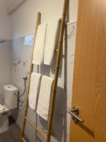 a towel rack in a bathroom with white towels at Casa na Quinta in Elvas