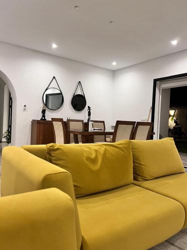 a yellow couch in a living room with a table at Villa julia in Hammamet