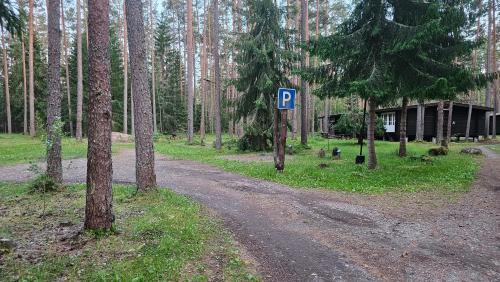 a dirt road with a parking sign in a forest at Viitna Puhkekeskus in Viitna