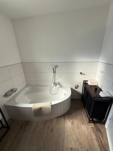 a white bath tub in a bathroom with a wooden floor at SUNSET RESIDENCE Attersee 