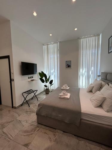 une chambre avec un grand lit et une télévision à écran plat dans l'établissement Tango Rooms, à Split