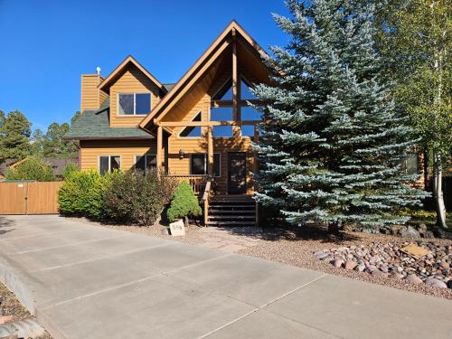 a house with a pine tree in front of it at Tree House Pinetop Az in Pinetop-Lakeside