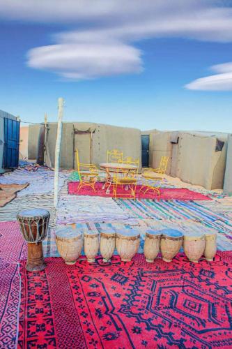 a room with a table and chairs on a rug at magical saharain camp in Merzouga