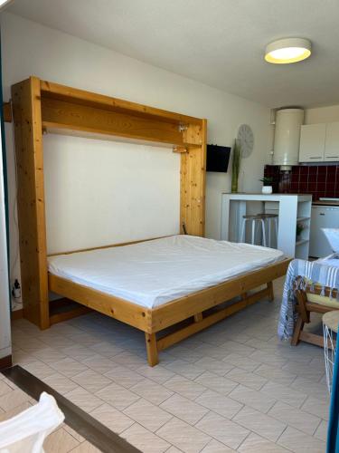 un lit avec un cadre en bois dans une chambre dans l'établissement Studio 100m de la mer et port, à Valras-Plage
