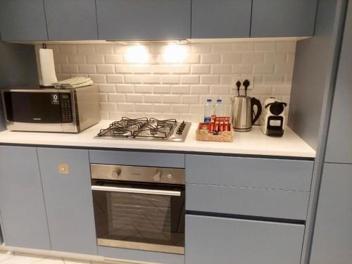 a kitchen with a stove and a microwave at Cozy Apartment with Private Beach, couples and families only in Aqaba