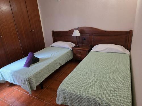 a bedroom with two beds and a table with a lamp at Casa Luz in Playa Santiago in Alajeró