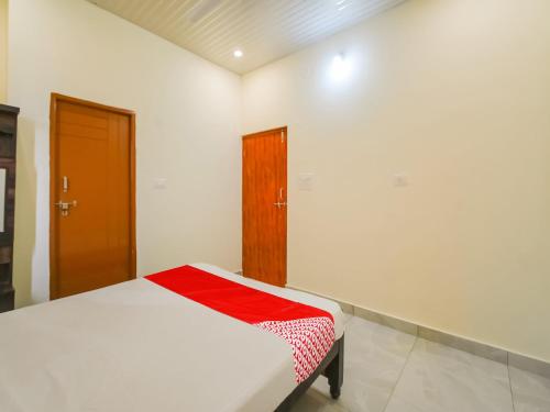 a bedroom with a bed with a red blanket on it at Hotel O GS Lodge in Hyderabad
