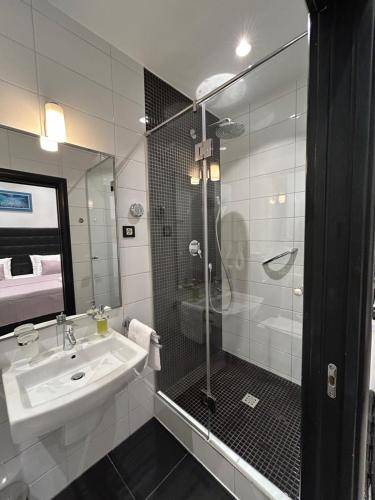 une salle de bain avec un lavabo et une douche en verre dans l'établissement Tango Rooms, à Split