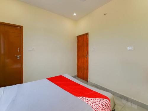 a bedroom with a bed and a wooden door at Hotel O GS Lodge in Hyderabad