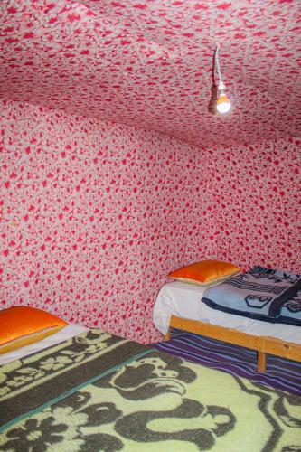 a bedroom with two beds and a pink patterned wall at magical saharain camp in Merzouga