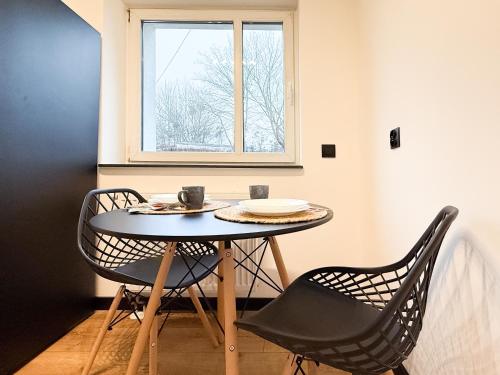 un tavolo da pranzo con due sedie e una finestra di Apartament Cichy na parterze Mrągowo a Mrągowo