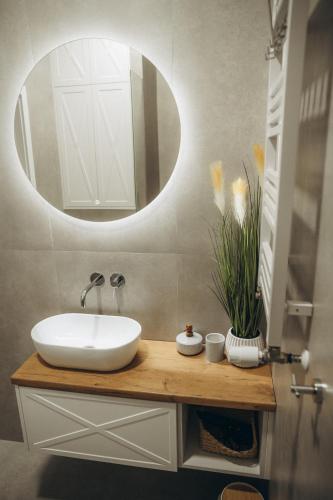 a bathroom with a white sink and a mirror at Nad Zatoką Ukiel in Olsztyn