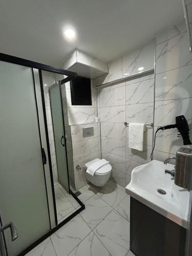 a bathroom with a toilet and a shower and a sink at Sara Suit in Istanbul