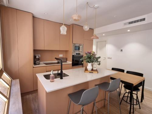 eine Küche mit einer Insel mit Stühlen und einer Arbeitsplatte in der Unterkunft Las Suites de Platería in Murcia