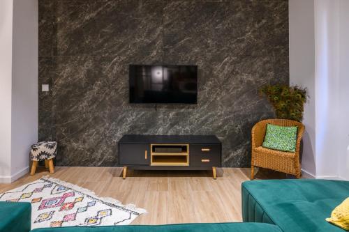 ein Wohnzimmer mit einem Flachbildfernseher an der Wand in der Unterkunft Las Suites de Platería in Murcia