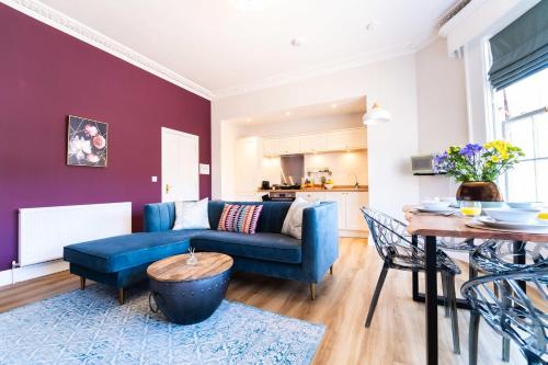a living room with a blue couch and a table at King Street Residence - 2 Bed in Great Yarmouth