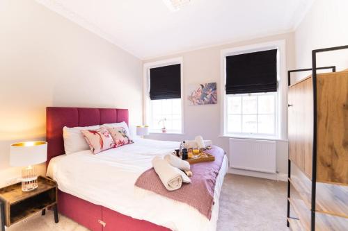 a bedroom with a large bed and two windows at King Street Residence - 2 Bed in Great Yarmouth