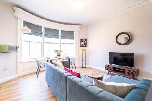 a living room with a blue couch and a tv at King Street Residence - 2 Bed in Great Yarmouth