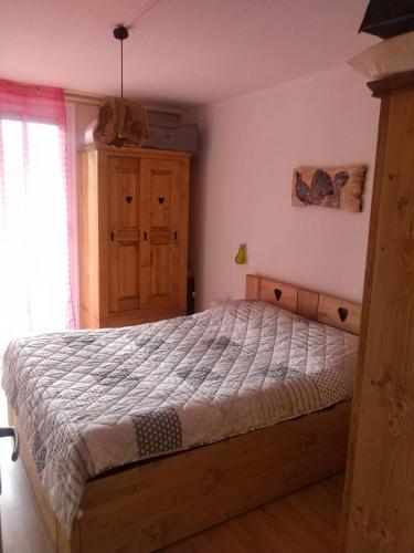 une chambre avec un lit et une armoire en bois dans l'établissement Appartement en residence, aux Angles