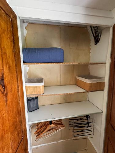 a cupboard with a bed and boxes in it at Au Clos de la Bergerie - campagne, détente & pétanque in Pont-lʼÉvêque