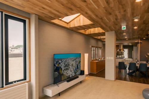 a living room with a flat screen tv on a wall at Cooee函館byTAKADAYA in Hakodate