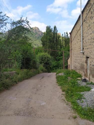 an empty dirt road next to a brick wall at Verishen Guest House B&B in Goris