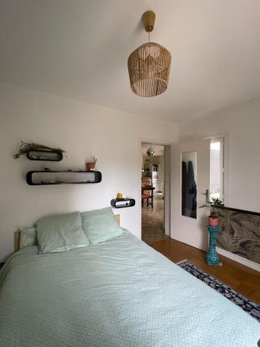 une chambre avec un lit avec une couette bleue dans l'établissement Jardin, plage et commerce à 200m, à Bénodet