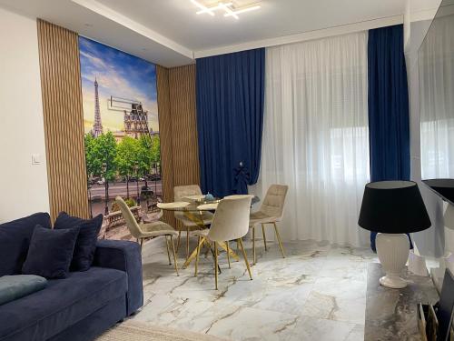 a living room with a blue couch and a table at Apartament Paris in Uniejow