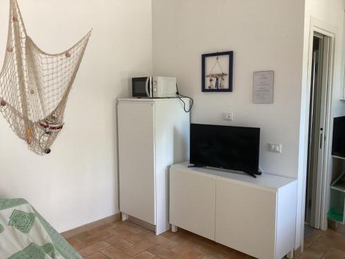 a white refrigerator with a microwave on top of it at Casa VITTORIA in Procchio