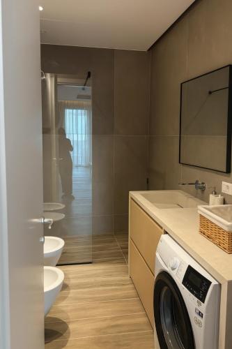 a bathroom with a washing machine and a sink at Turquoise Poolside Thymus Resort 34-1 in Dhërmi