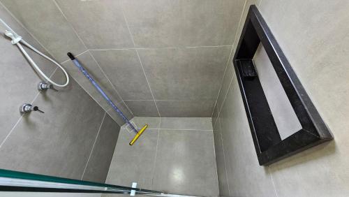 a shower with a yellow handle in a bathroom at Spazio Italia Apartamentos - Você entre a Lagoa e a Praia in Ilha Comprida